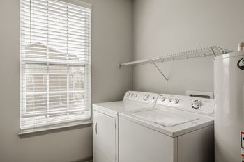 A white washing machine and dryer in a laundry room